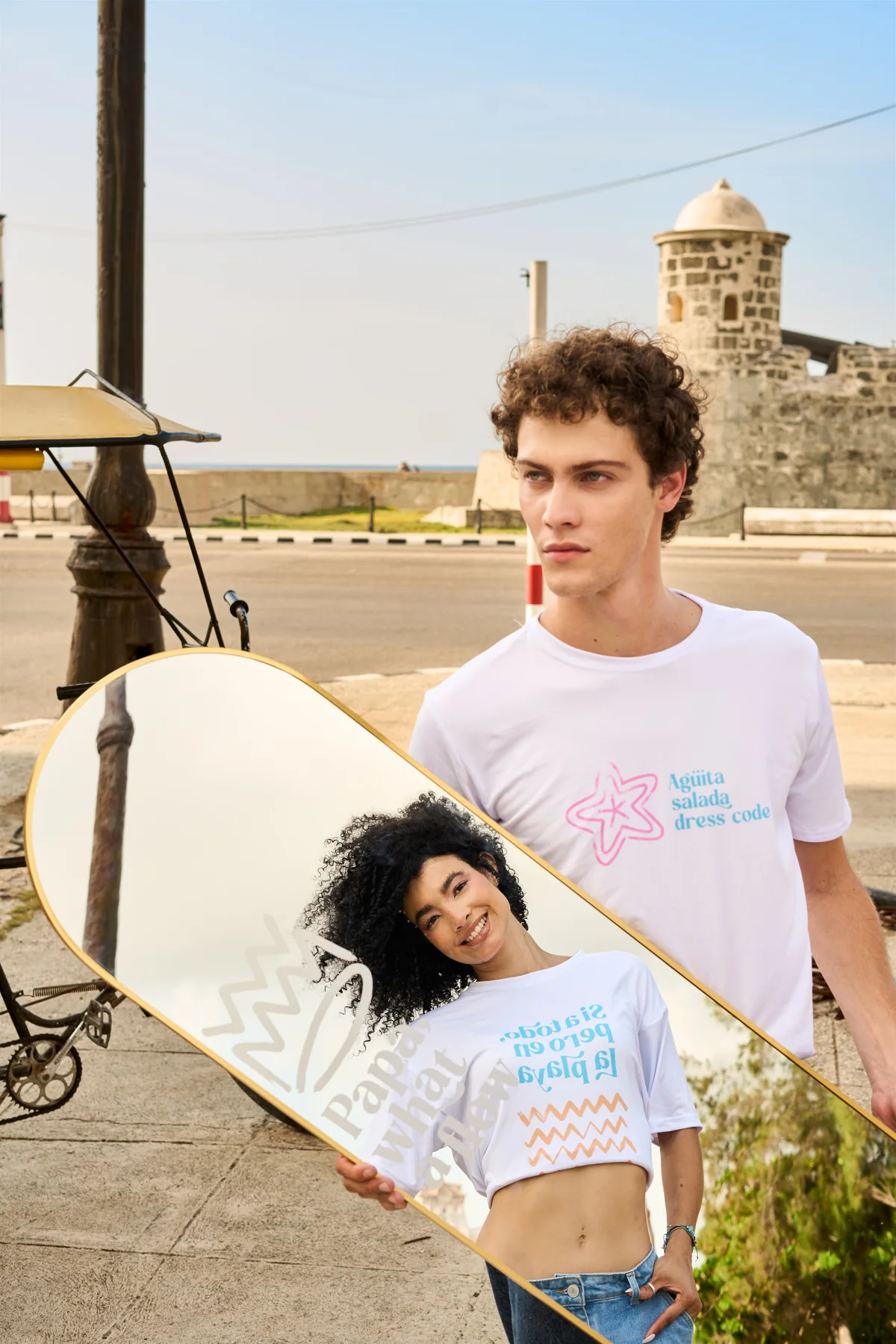 dos modelos con las camisetas frente al mar