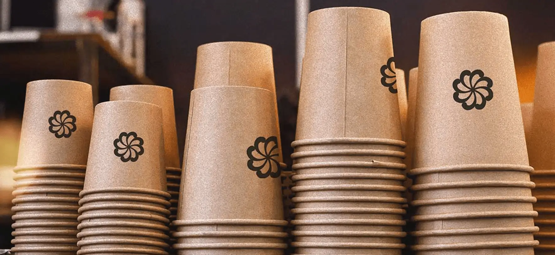 Vasos desechables con diseño de marca Ecocraft en fondo claro